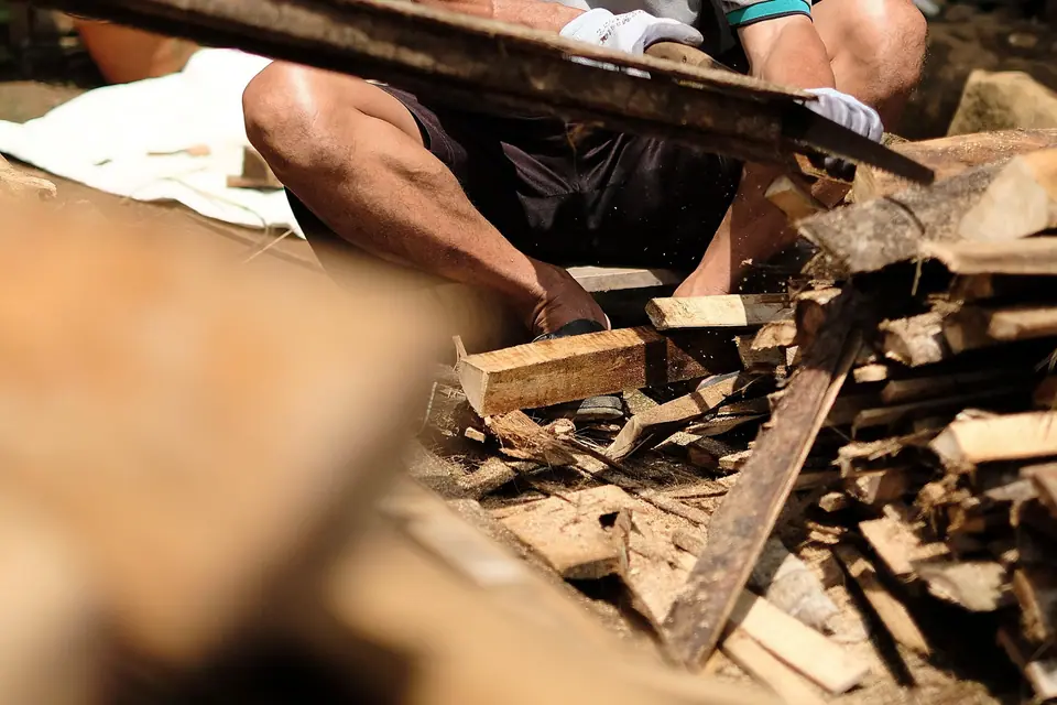A craftsman working at ground level among wood off-cuts